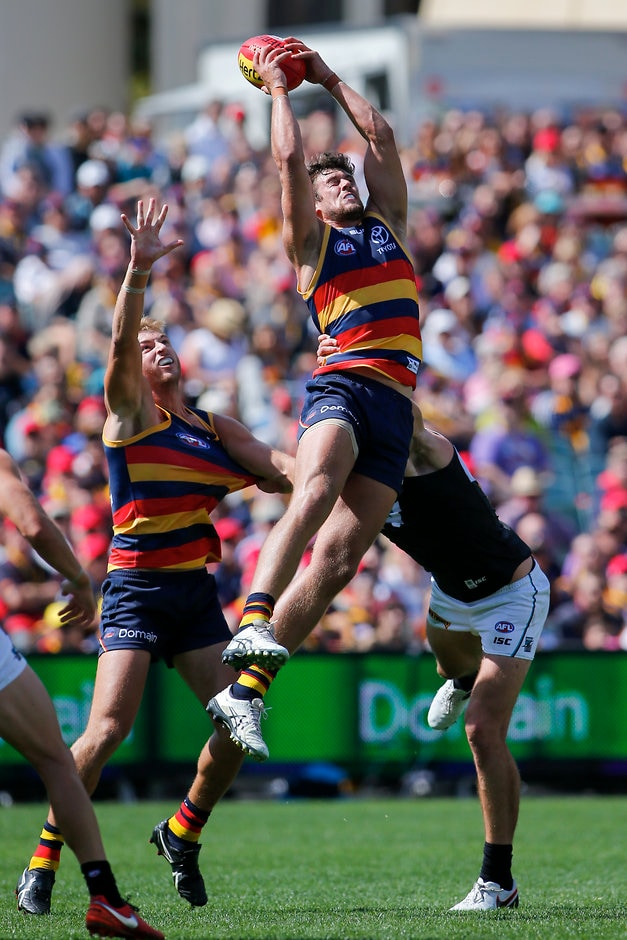 AFL 2016 Rd 02 - Adelaide v Port Adelaide ADELAIDE, AUSTRALIA - APRIL 2: Kyle Hartigan of the Crows marks in front of team mate Daniel Talia and Charlie Dixon of the Power during the 2016 AFL Round 02 match between the Adelaide Crows and Port Adelaide Power at the Adelaide Oval, Adelaide on April 2, 2016. (Photo by /AFL Media)